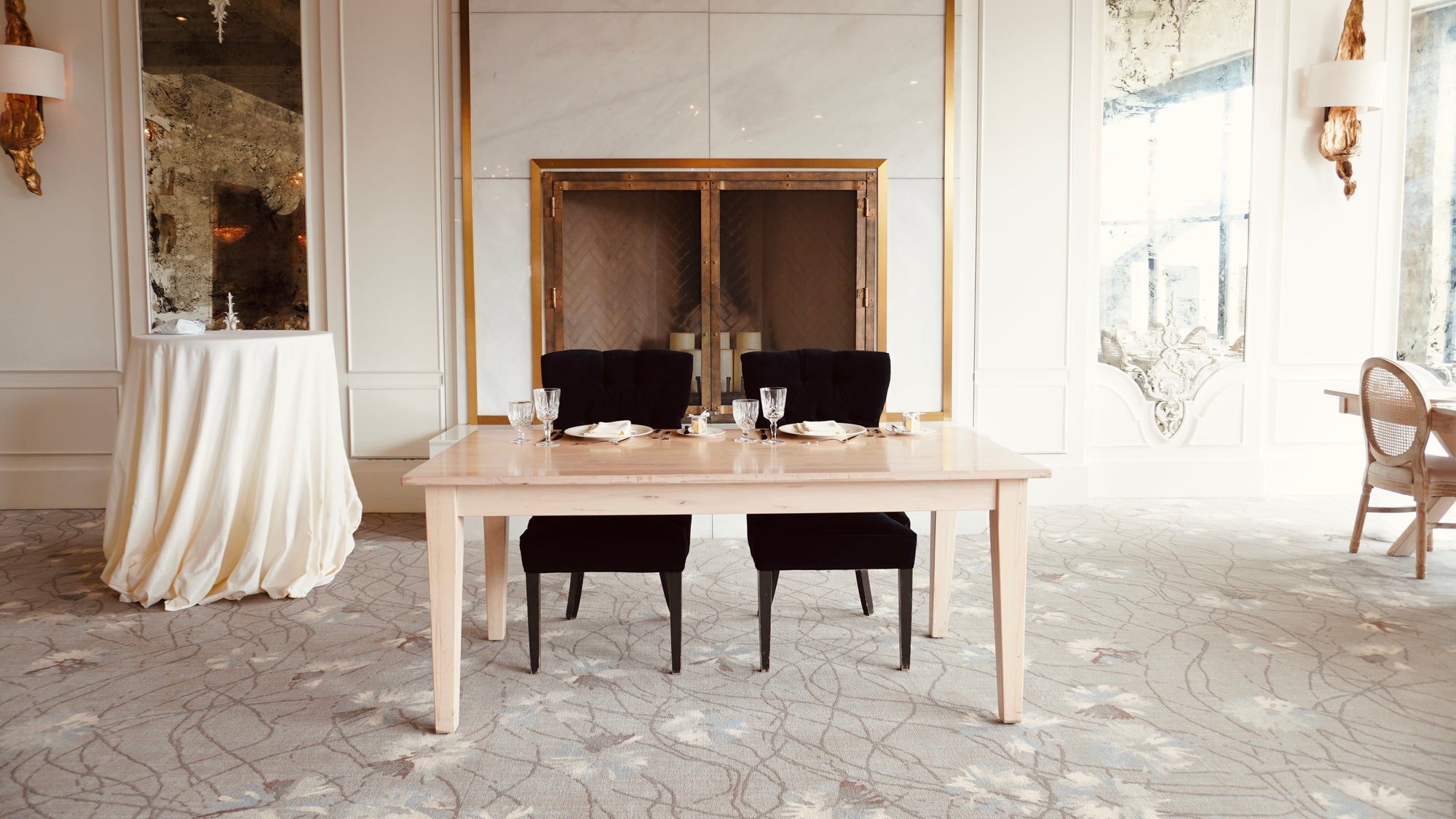 Dining room with a wooden table and black chairs in a well-lit room.